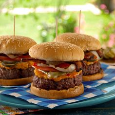 three hamburgers sitting on top of a blue plate