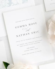 the wedding stationery is laid out on top of each other, with flowers in front