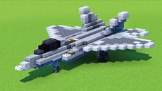 an airplane made out of lego blocks sitting on top of a green field