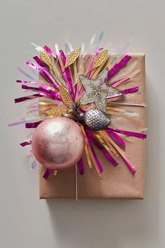 a present wrapped in brown paper with pink and gold decorations