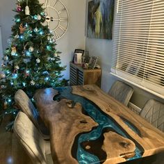 a christmas tree is in the corner of a room with a wooden table and chairs