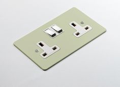 a light green switch plate with two white outlets