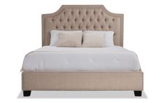 an upholstered bed with two pillows on the headboard and one foot board