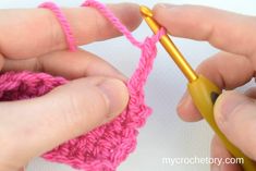 two hands crocheting the end of a pink piece of yarn with a yellow crochet hook