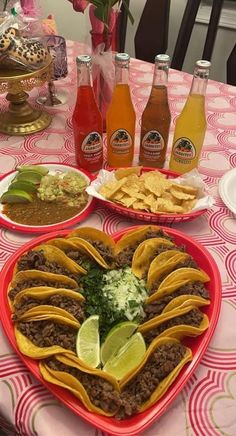 a heart shaped plate filled with tacos, salsa and tortillas