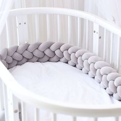 a white crib with some pillows in it