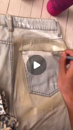 someone is using a pen to draw on their pants