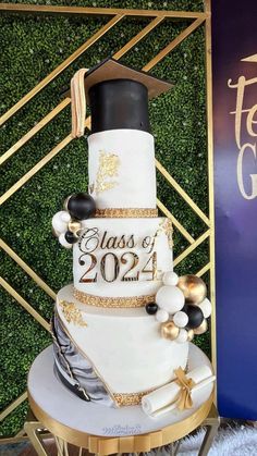 a white and gold graduation cake sitting on top of a table