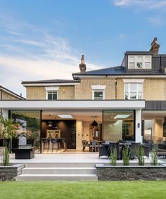 a modern house with an outdoor patio and dining area