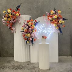 two white vases with flowers on them and the word trust spelled in neon letters