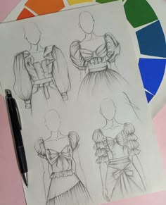 three different types of dresses drawn on paper next to a color swatch with a pen