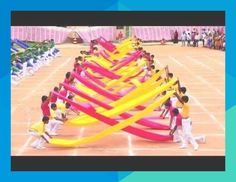 a group of people standing next to each other in front of a row of colorful ribbons