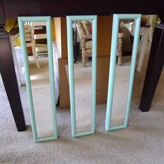 a mirror sitting on top of a wooden table next to a white carpeted floor