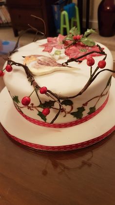 a white cake decorated with holly and berries