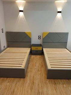 there are two beds in the room with yellow and gray headboards on each side