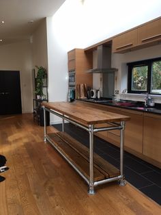 a kitchen with wooden flooring and stainless steel counter tops in the middle of it