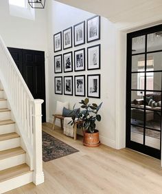 a living room with stairs and pictures on the wall