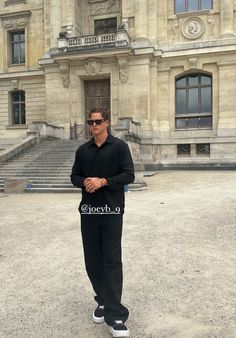 a man standing in front of a large building