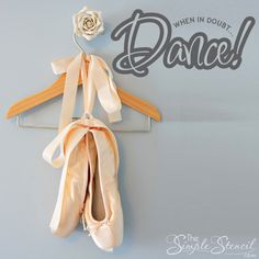 a pair of ballet shoes hanging on a rack with the word dance written above it