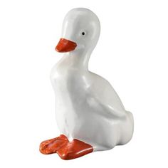 a white duck with an orange beak sitting on the ground in front of a white background