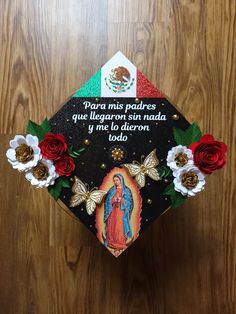 a graduation cap decorated with flowers and an image of the virgin mary in spanish on it