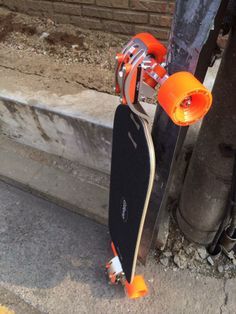 an orange and black skateboard sitting on the ground