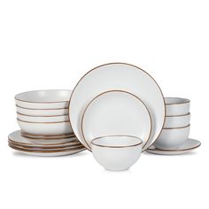 a stack of white and gold dinnerware on top of each other with brown rims