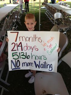 a young boy holding up a sign that reads 7 months, 24 days and 51 hours no more waiting