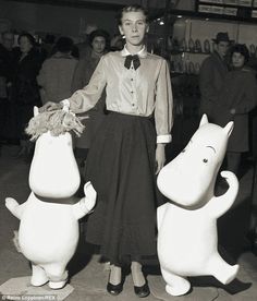 a woman standing next to two large stuffed animals