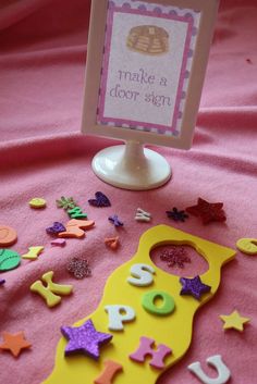 there is a sign that says make a door sign on the pink sheeted tablecloth