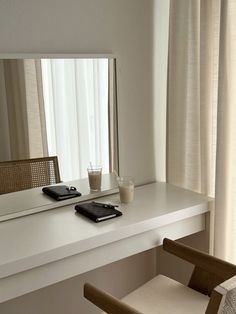 a table with a cell phone on it next to a chair and a large mirror