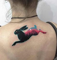 a woman with a rabbit tattoo on her back