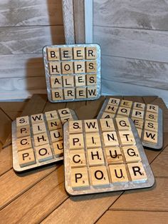 three coasters with words on them sitting on the floor in front of a door