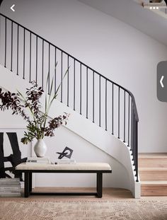 a vase filled with flowers sitting on top of a table next to a stair case