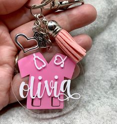 a person holding a key chain with a pink house shaped keychain on it