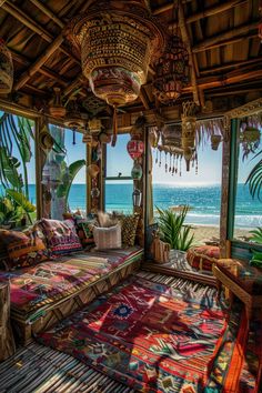 a living room with a couch and rugs on the floor next to an ocean view