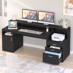 a computer desk with two monitors on top of it next to a printer and keyboard