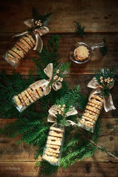 some food is wrapped in clear cellophane and tied with bows on a wooden table