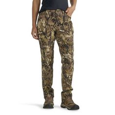 a man standing in front of a white background wearing camo pants and black t - shirt