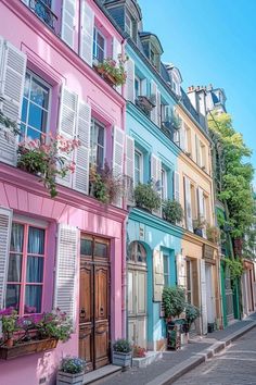 a row of multi - colored buildings with windows and shutters on each side in paris, france