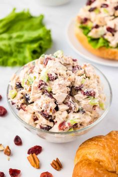 chicken salad with cranberries and pecans in a glass bowl on a white table