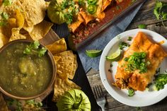 mexican food with salsa and tortilla chips on the side, including guacamole