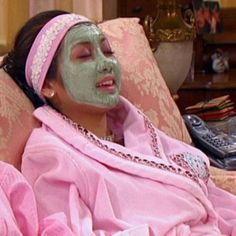 a woman laying on top of a couch covered in green facial mask