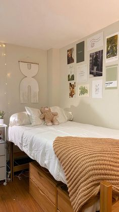 a bedroom with a bed, dresser and pictures on the wall above it's headboard