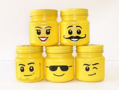 four yellow jars with faces painted on them