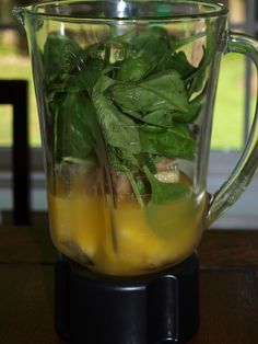 a blender filled with green leaves and liquid