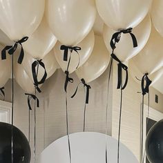 balloons are tied to the ceiling with black ribbon