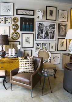 a living room filled with furniture and pictures on the wall