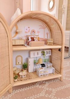 a doll house with furniture and accessories on display in a room that is decorated in wicker