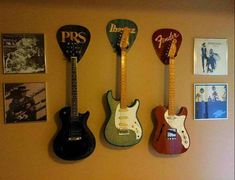 three guitars are hanging on the wall